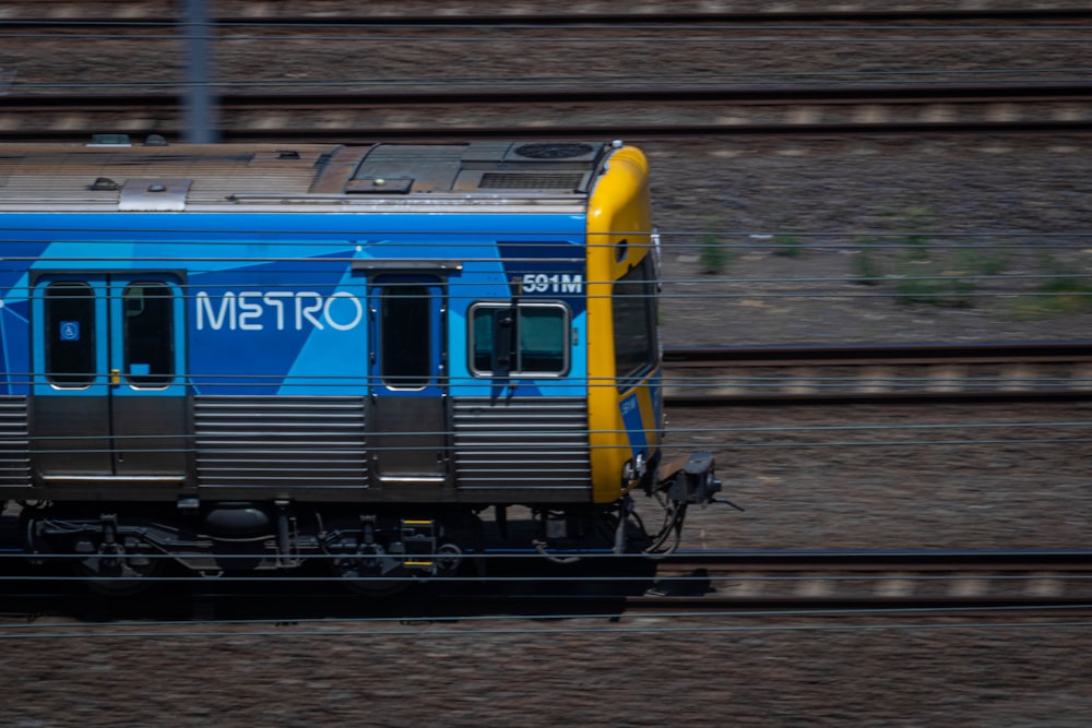 a blue and yellow train traveling down train tracks