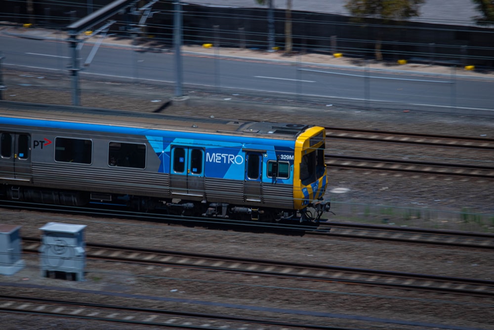 a blue and yellow train traveling down train tracks