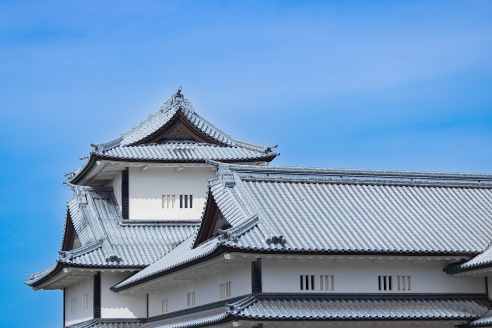 a white and black building with a blue sky in the background