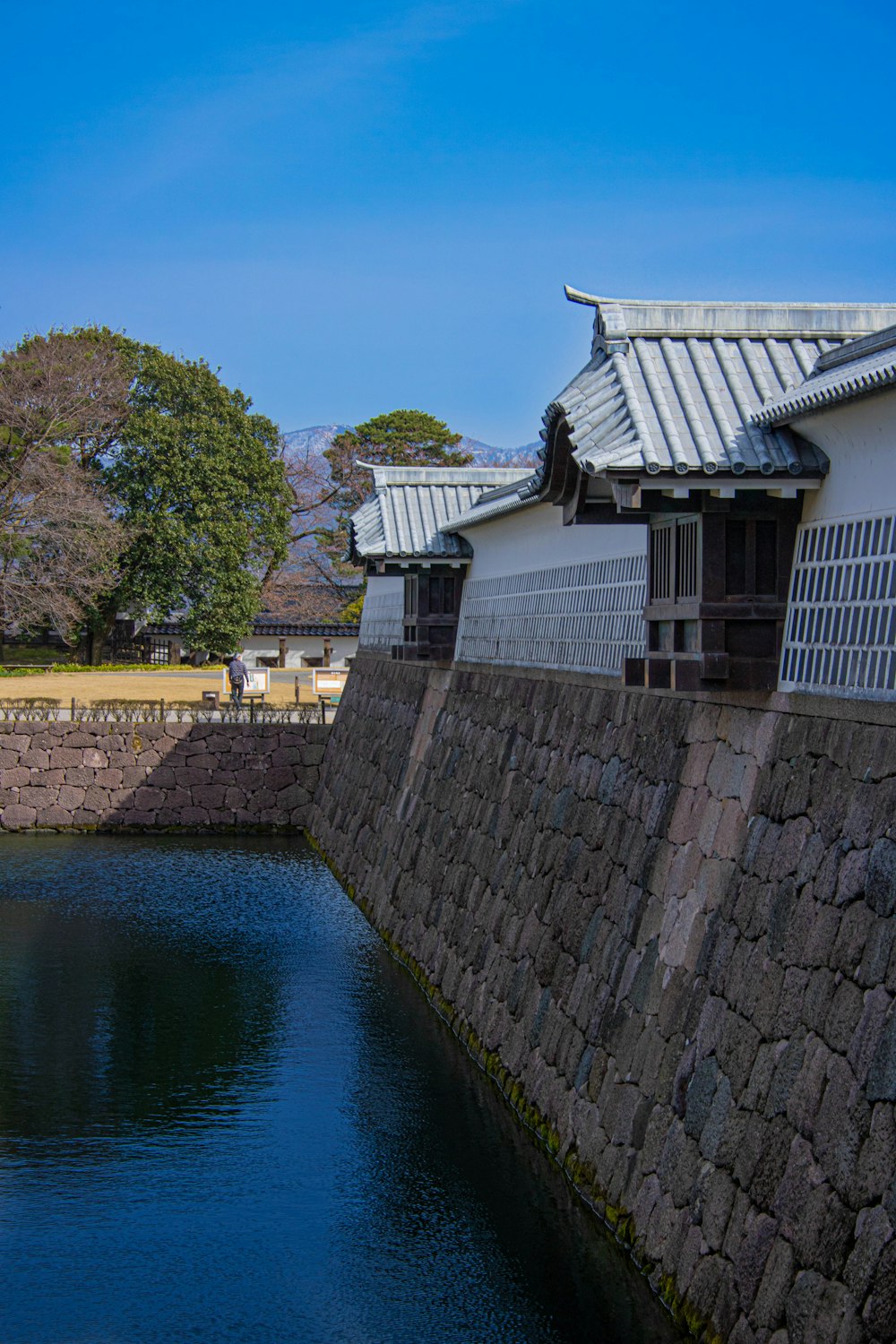 a body of water next to a stone wall