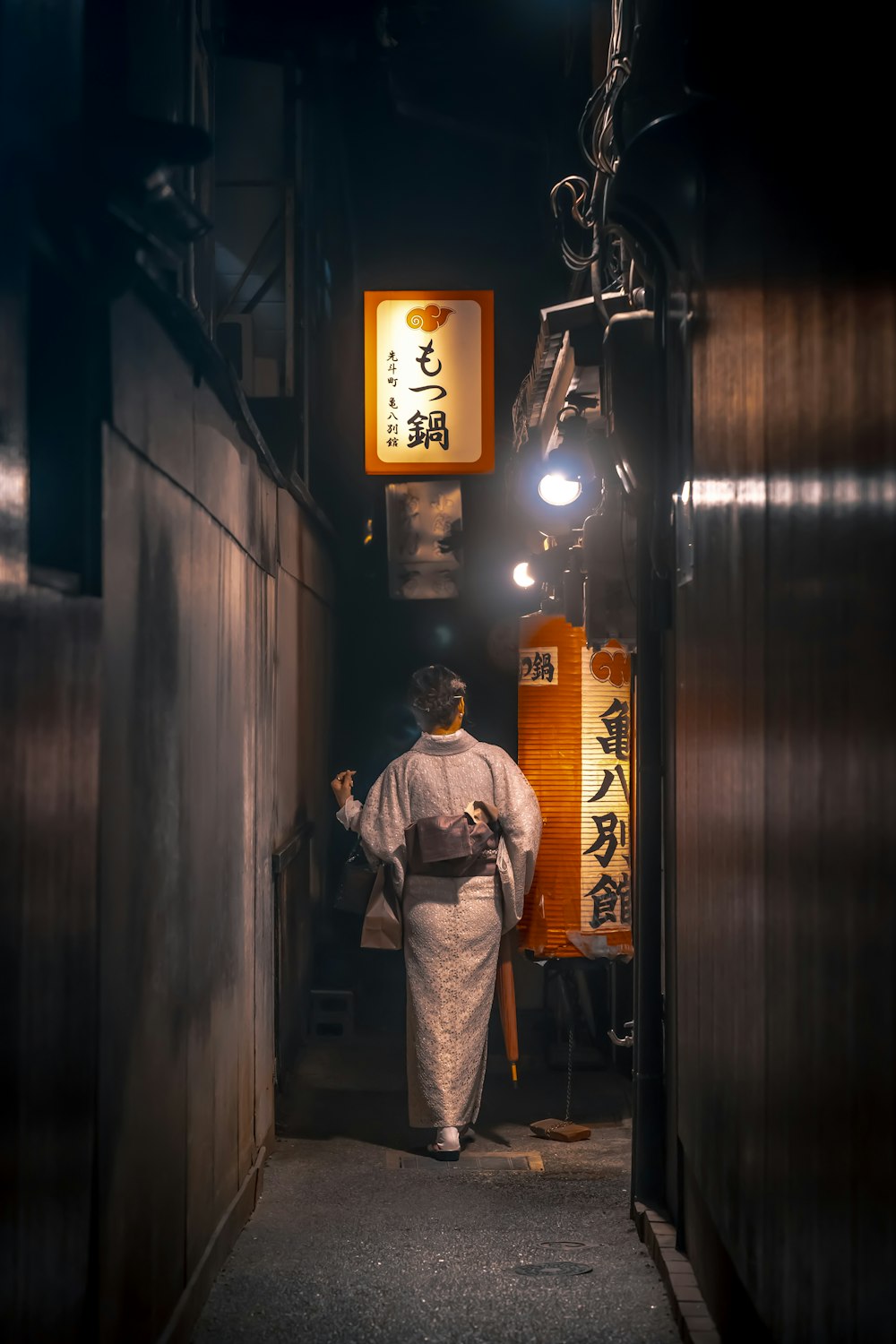 a man in a kimono walking down a dark alley