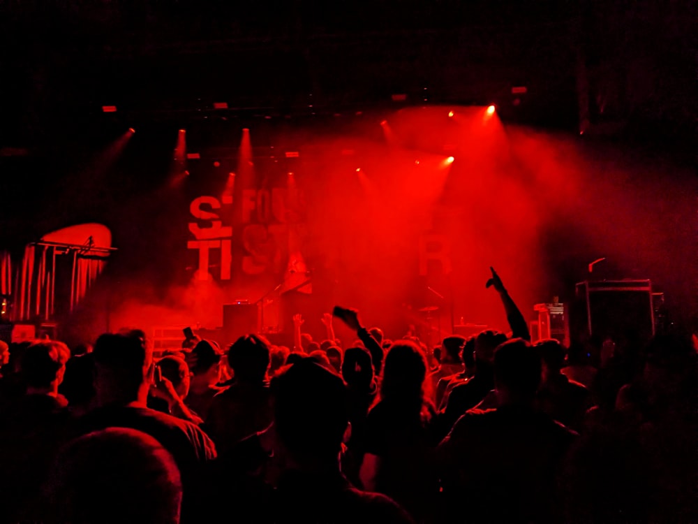 a crowd of people standing in front of a stage