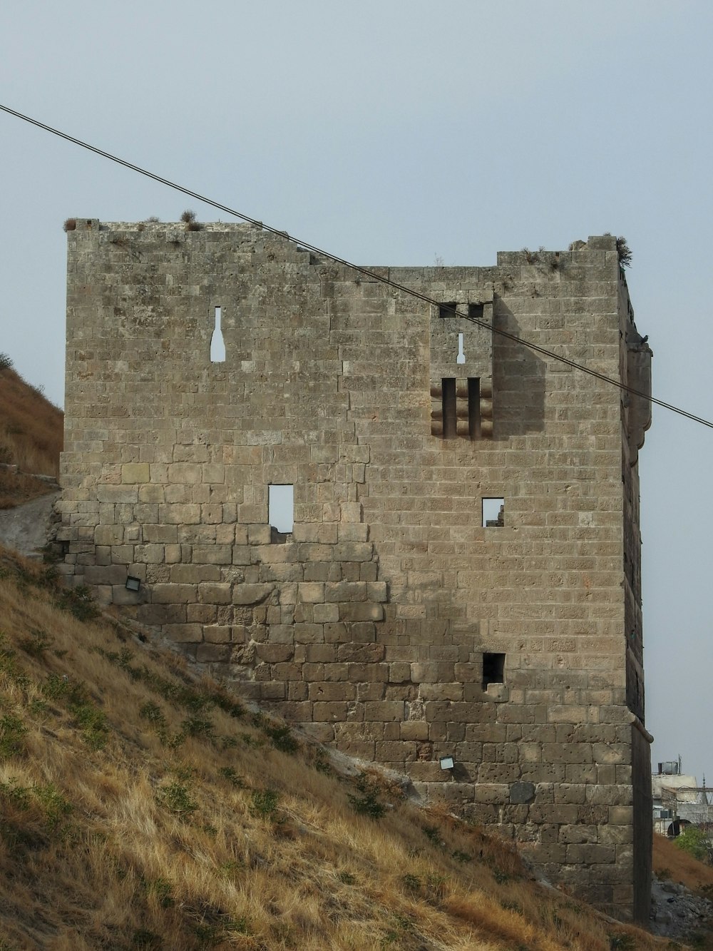 Un viejo edificio de ladrillo en la ladera de una colina