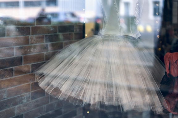 A delicate ballet tutu costume displayed on a mannequin with soft lighting highlighting its intricate details.