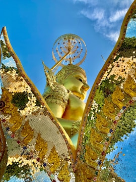 A vibrant brass idol shining under natural sunlight.