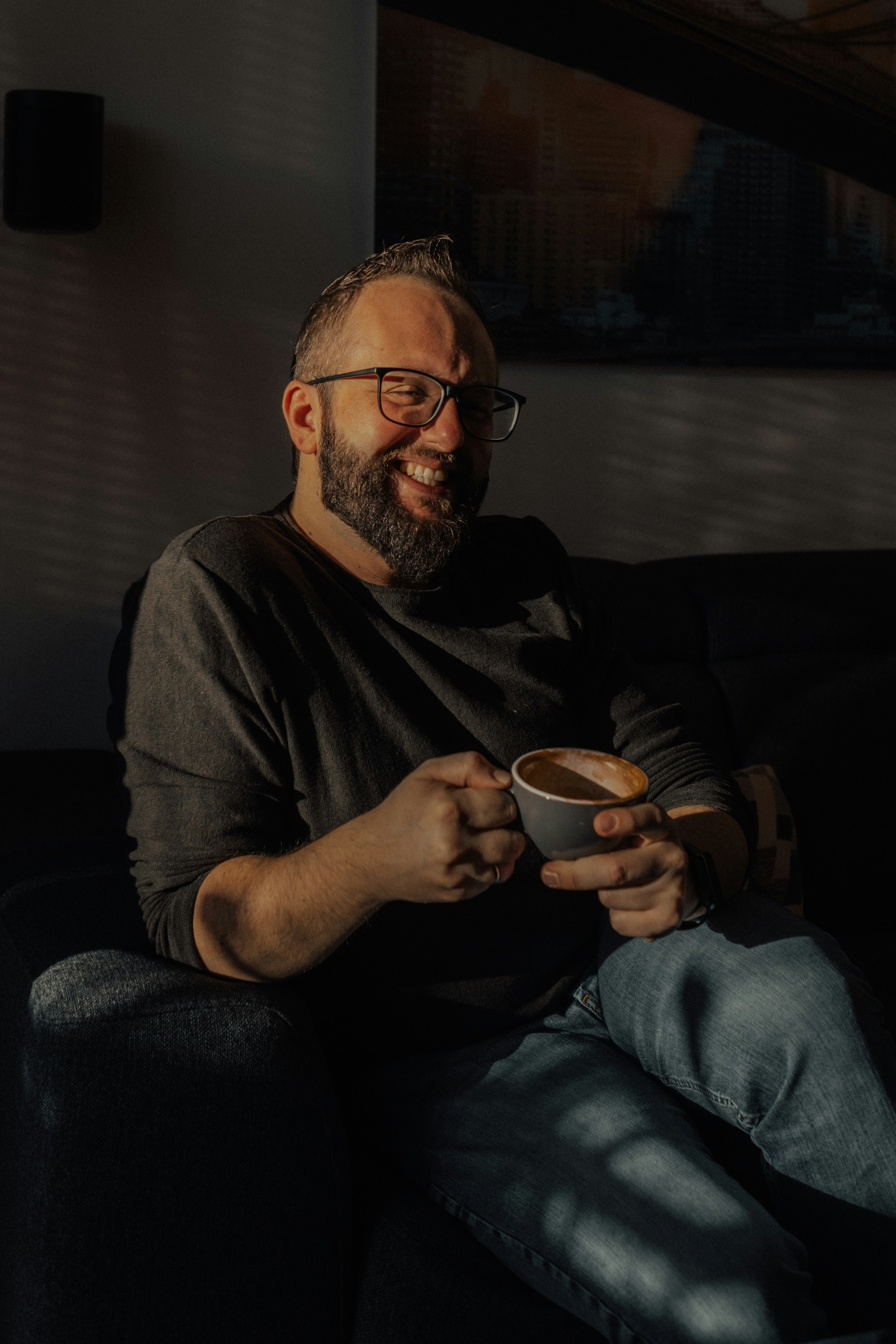 a man sitting on a couch holding a bowl of food
