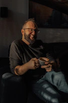Lifestyle shot of a man enjoying morning coffee, beard perfectly groomed, in a warm neutral-toned setting.