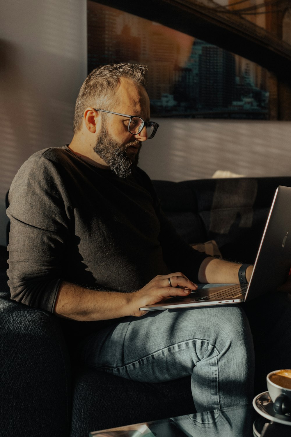 a man sitting on a couch using a laptop computer