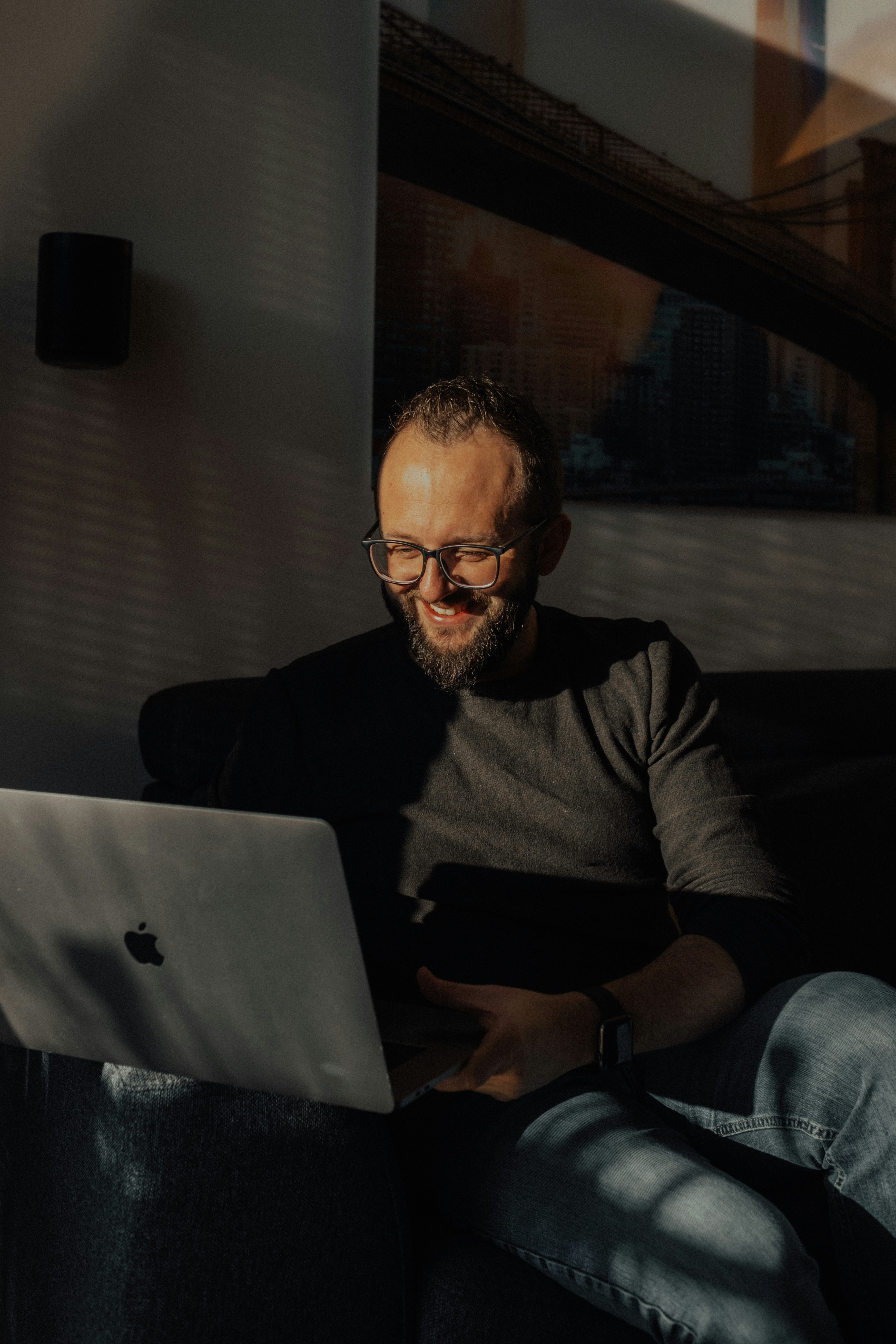 a man sitting on a couch using a laptop computer