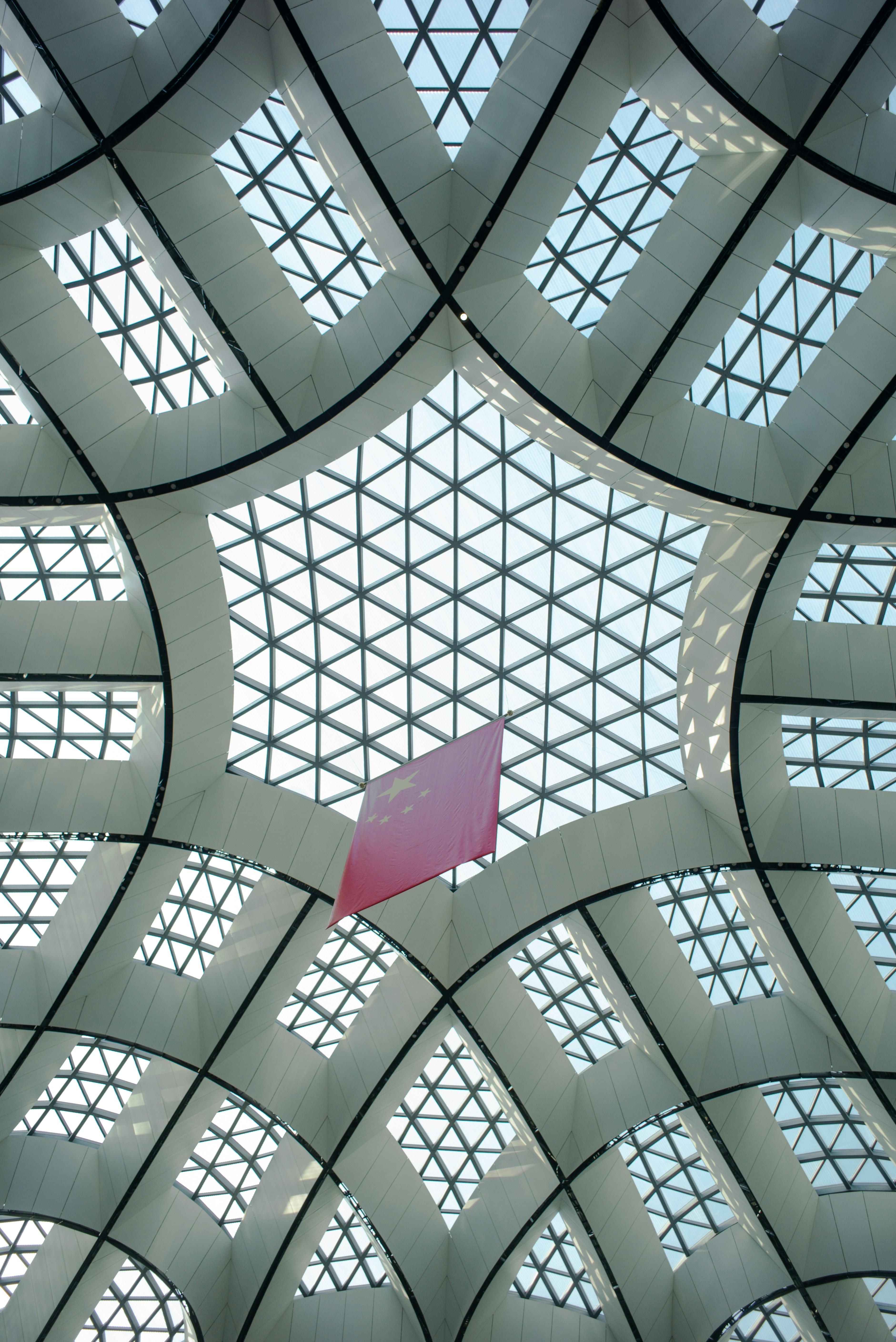 the ceiling of a building with a pink sign hanging from it