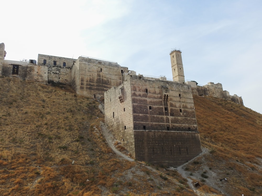 Un castillo muy alto en una colina con un fondo de cielo