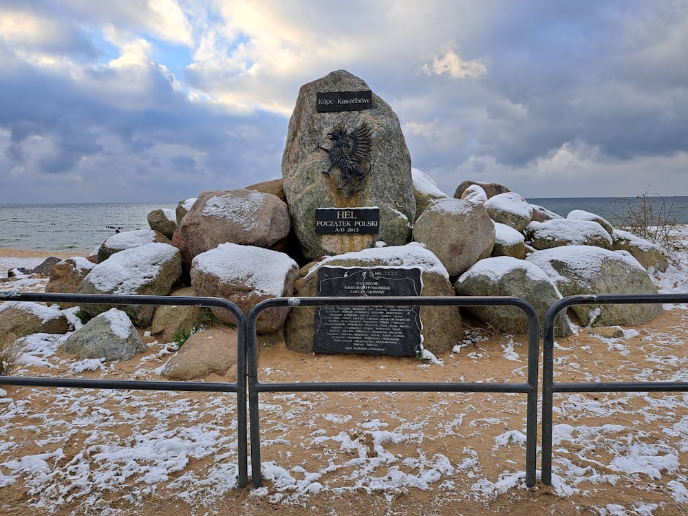 a large rock sitting on top of a beach covered in snow