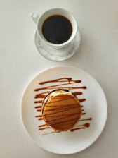 A beautifully arranged breakfast tray with pancakes, fruit, and coffee on a rustic table.