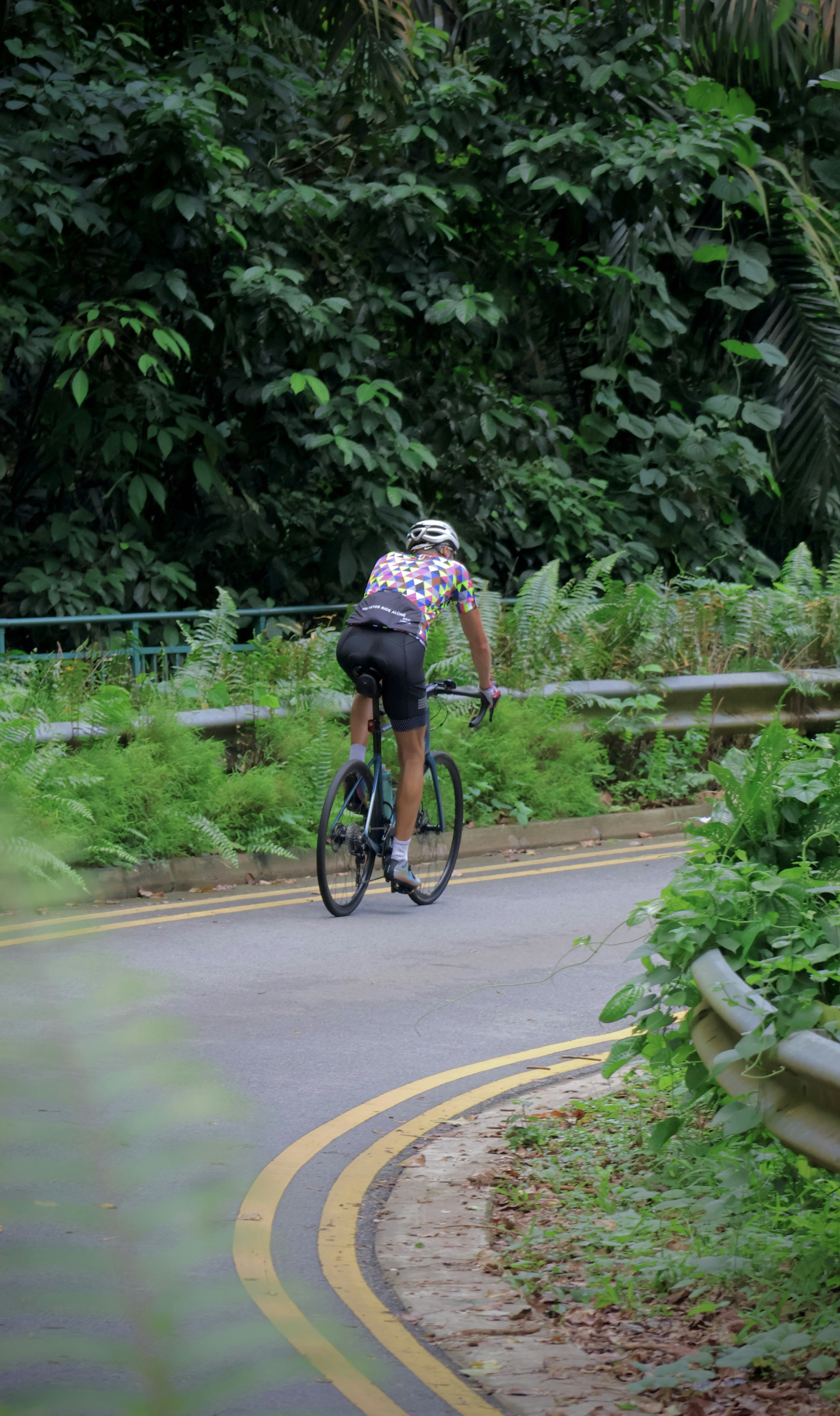 a man riding a bike down a curvy road