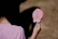 Smiling child holding a big lollipop with candy shelves blurred in the background.