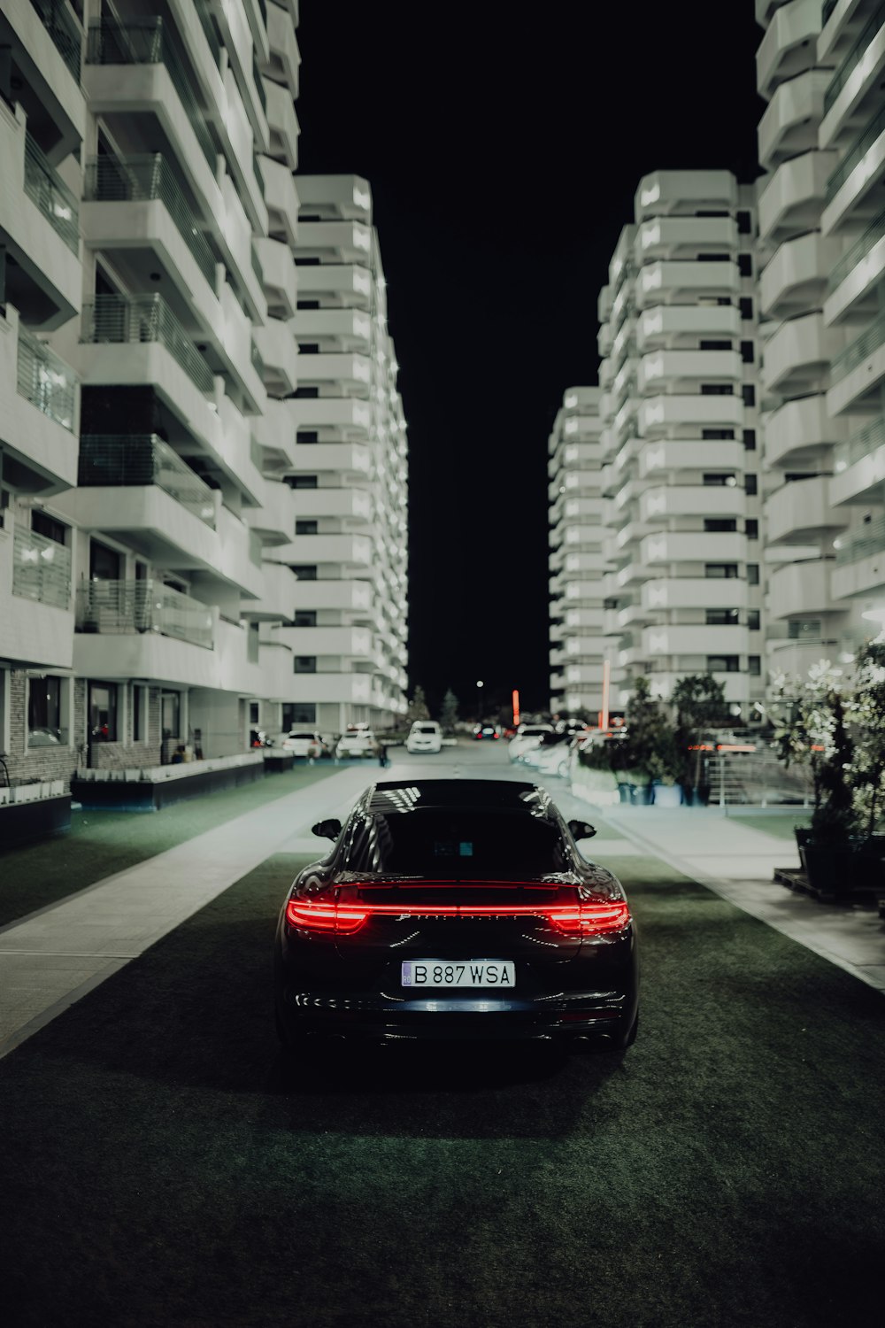 a car parked on the side of a road next to tall buildings