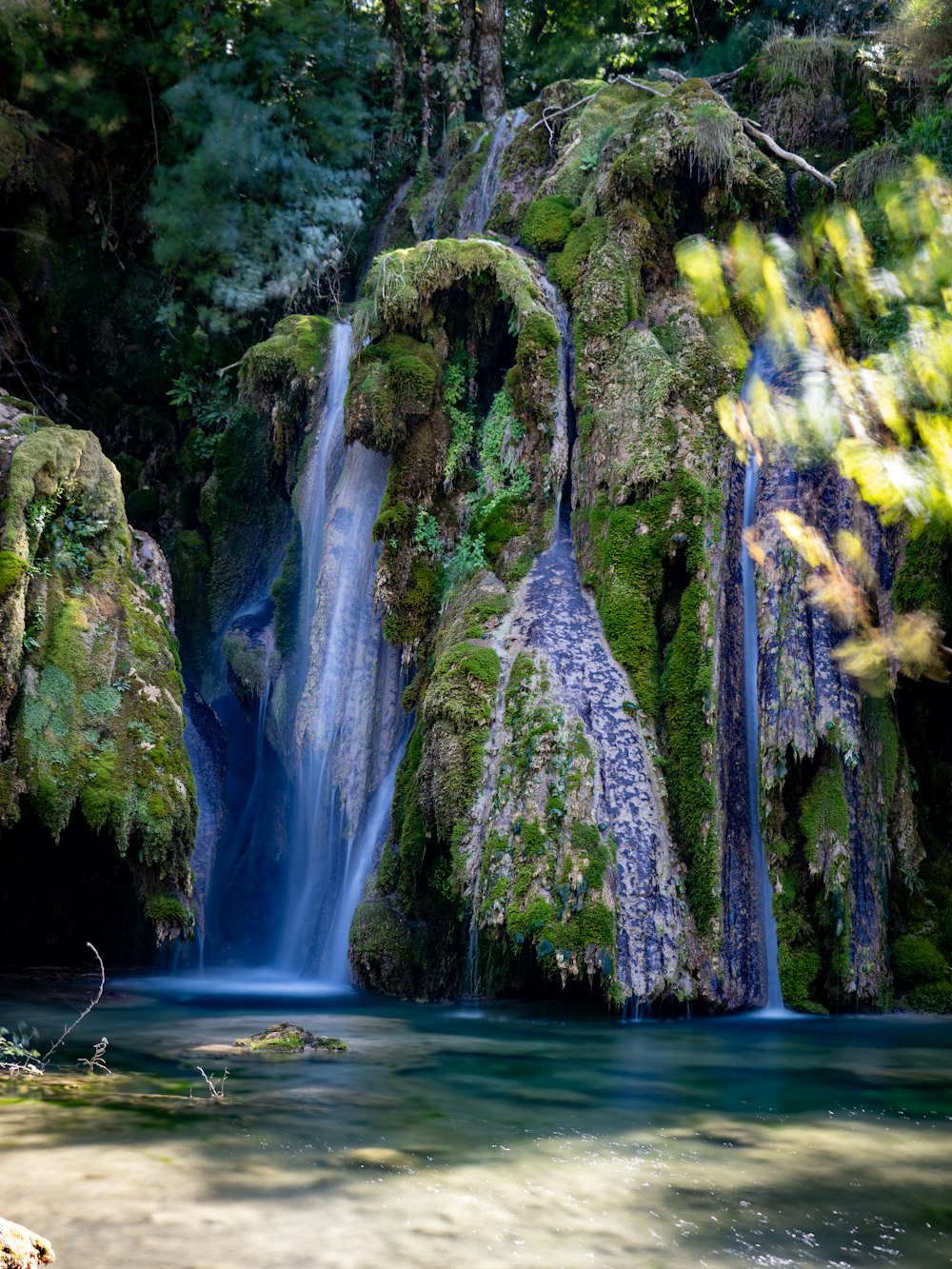 a small waterfall in the middle of a forest