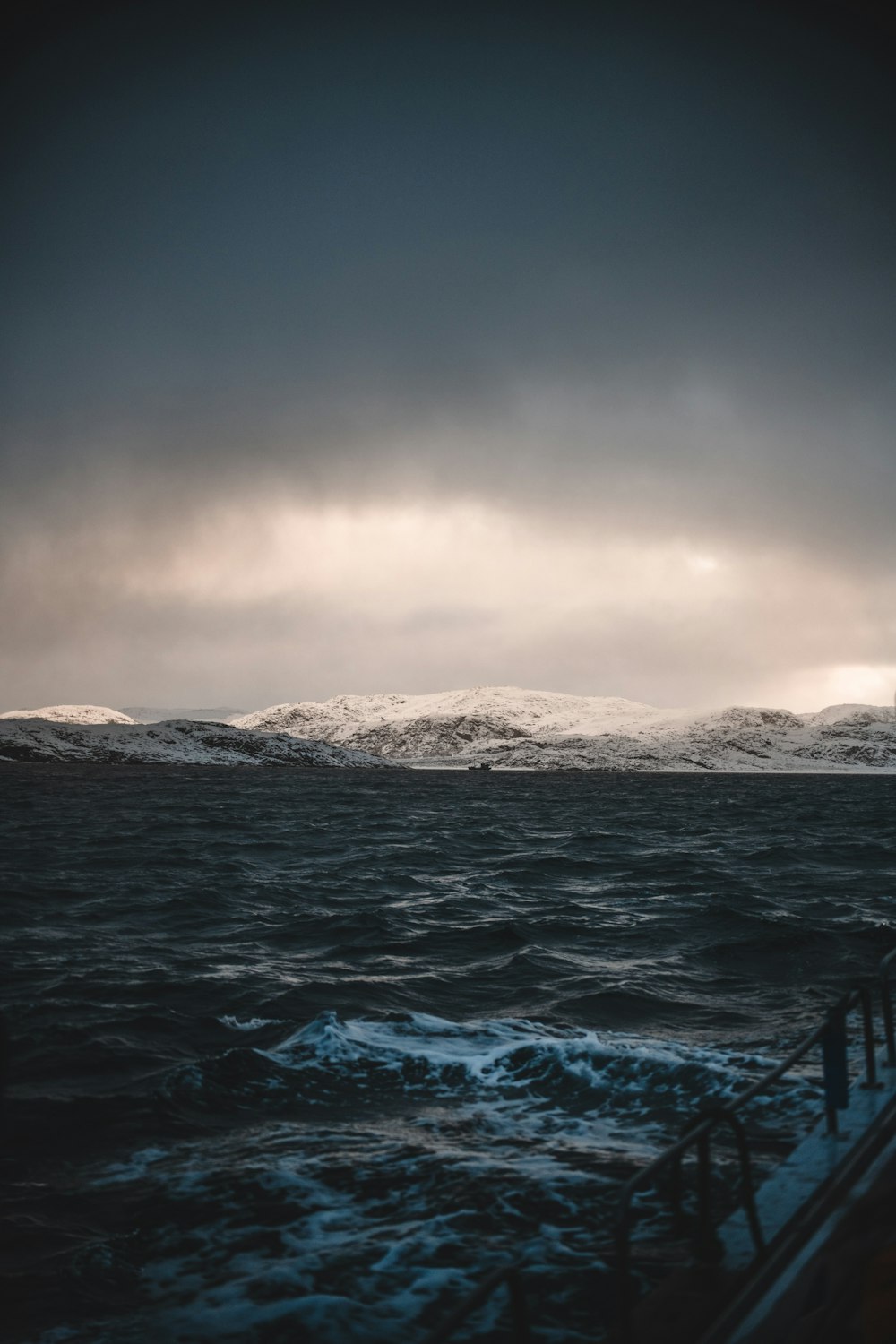 a boat in a body of water under a cloudy sky