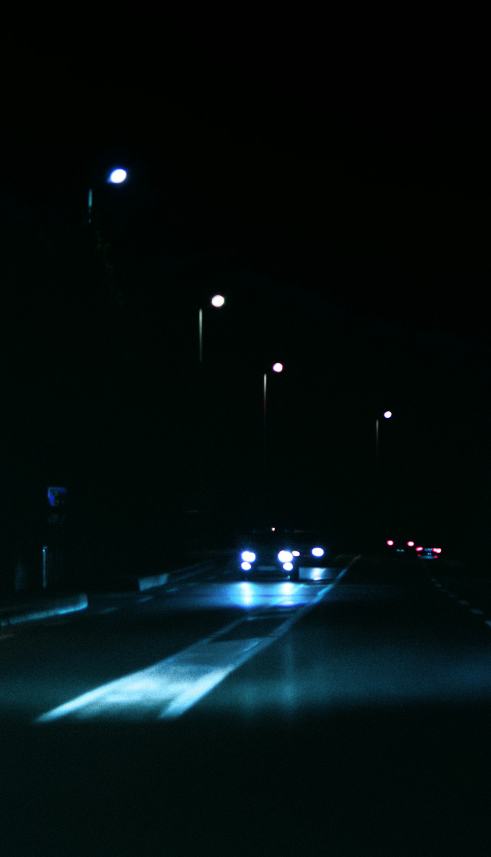 a car driving down a street at night