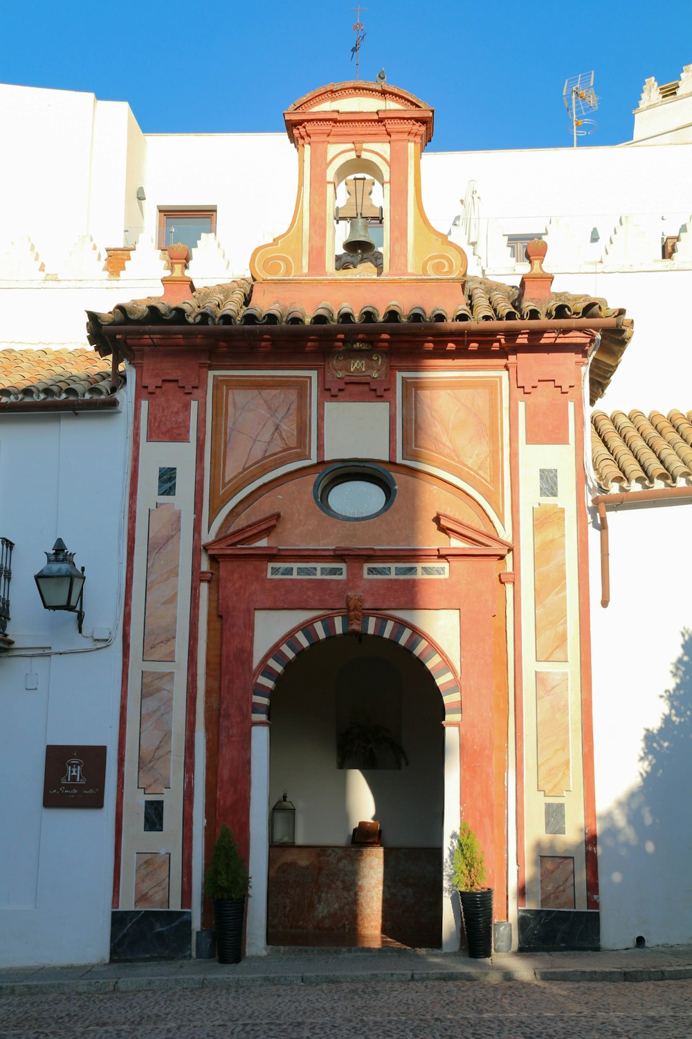 a red and white building with a bell tower
