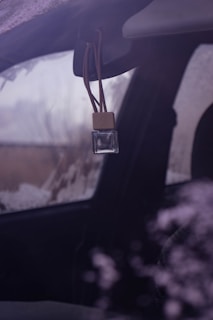 a car dashboard with a brown tag hanging from it's side window