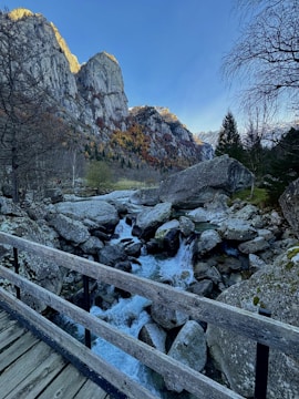a wooden bridge over a stream in the mountains