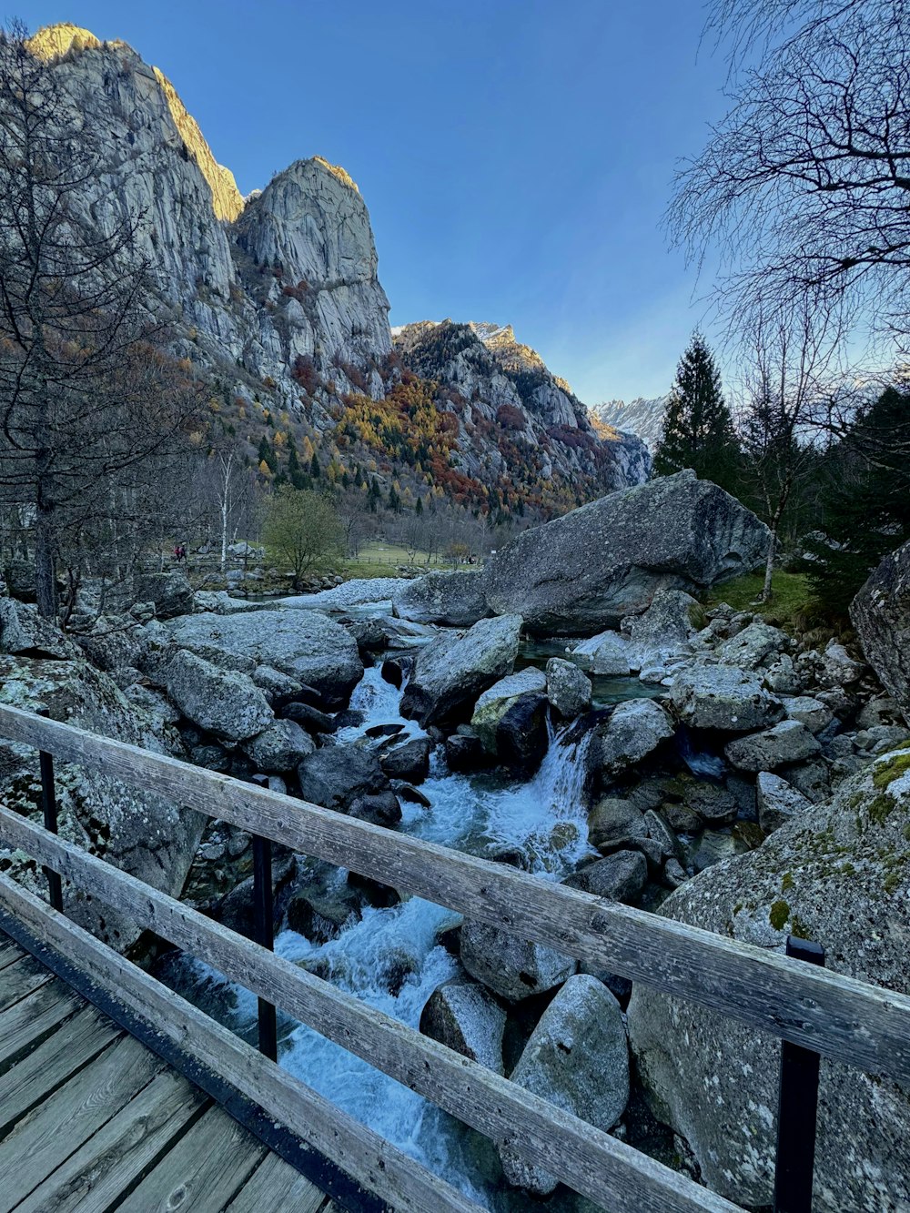 a wooden bridge over a stream in the mountains