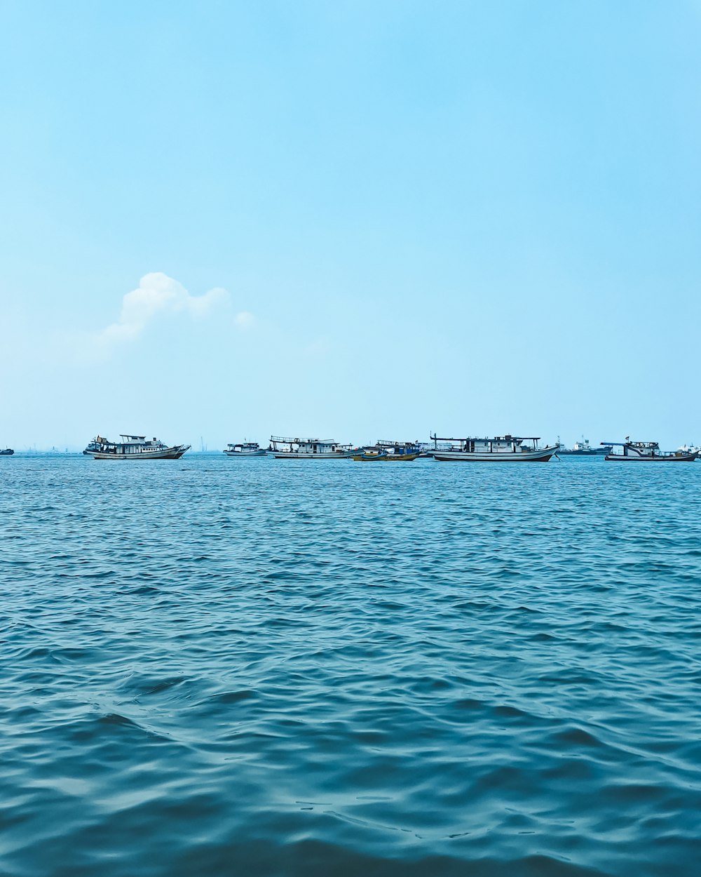 a group of boats floating on top of a large body of water