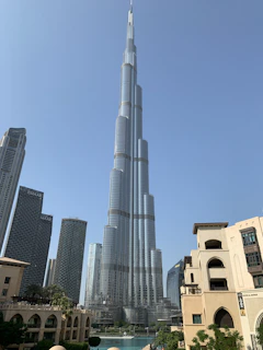The towering Burj Khalifa piercing the clear blue sky in Dubai, surrounded by modern skyscrapers.