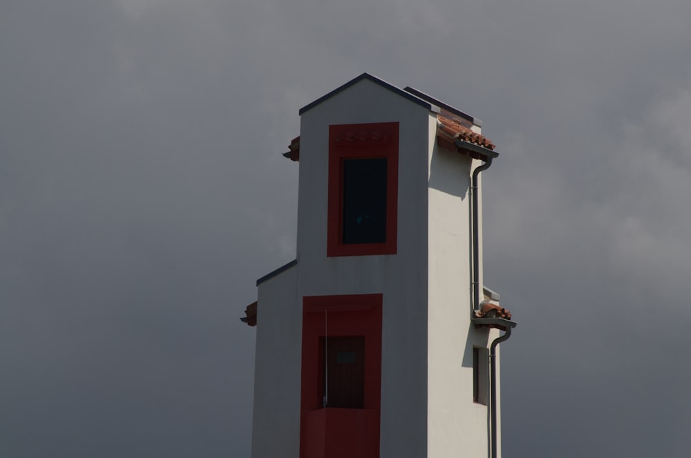 a white and red tower with a clock on it
