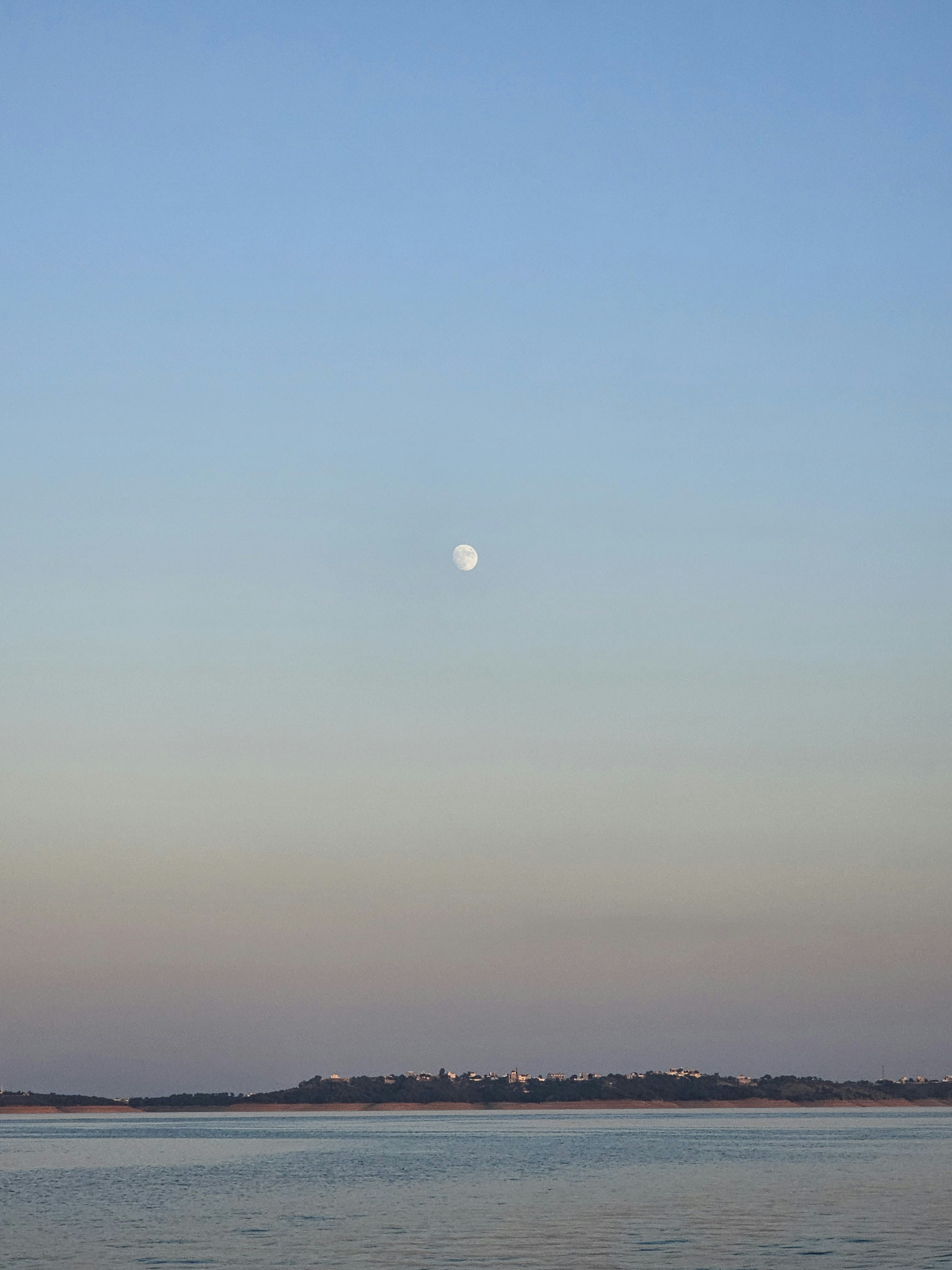 Luna llena brillando sobre paisaje oscuro y tranquilo con cielo estrellado profundo