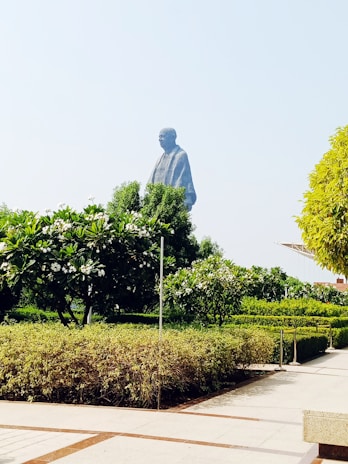 A wide shot of a lush backyard featuring several Boteler Concrete Statuary pieces arranged around a stone pathway.