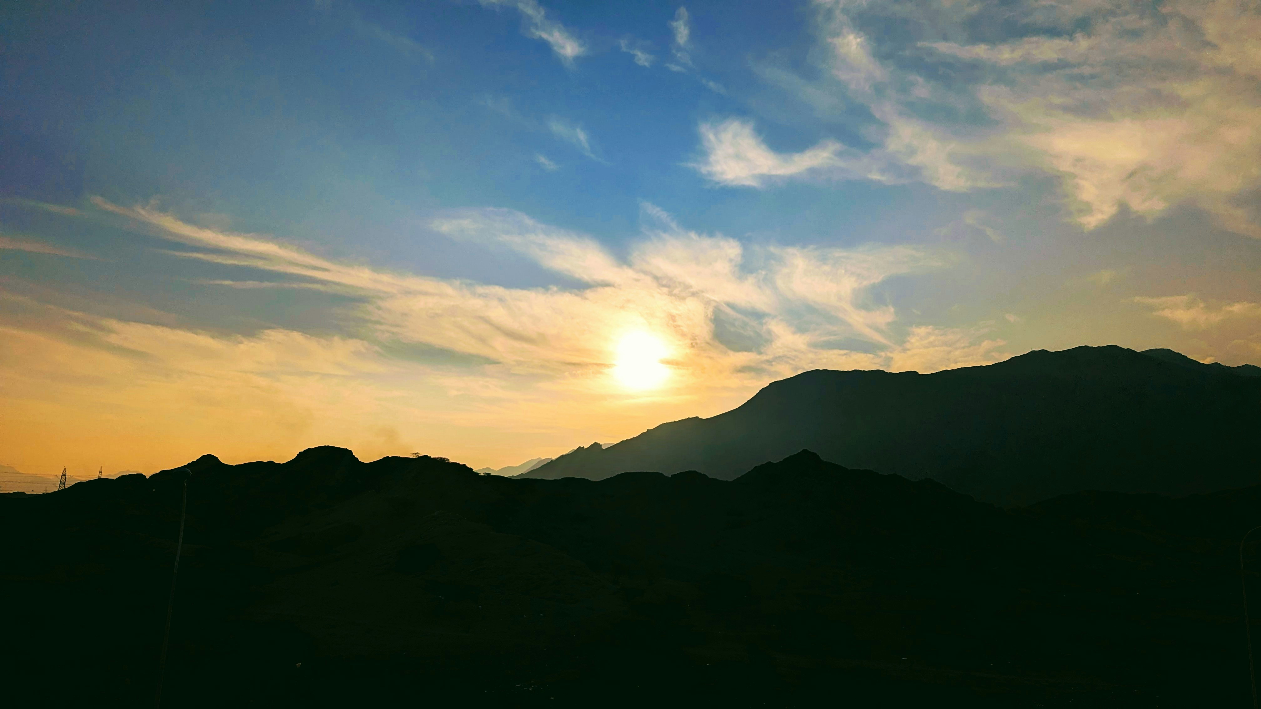 the sun is setting over a mountain range