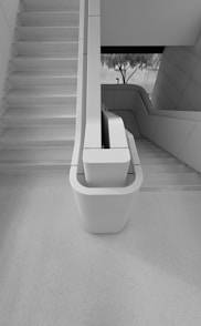 a white toilet sitting in a bathroom next to a stair case