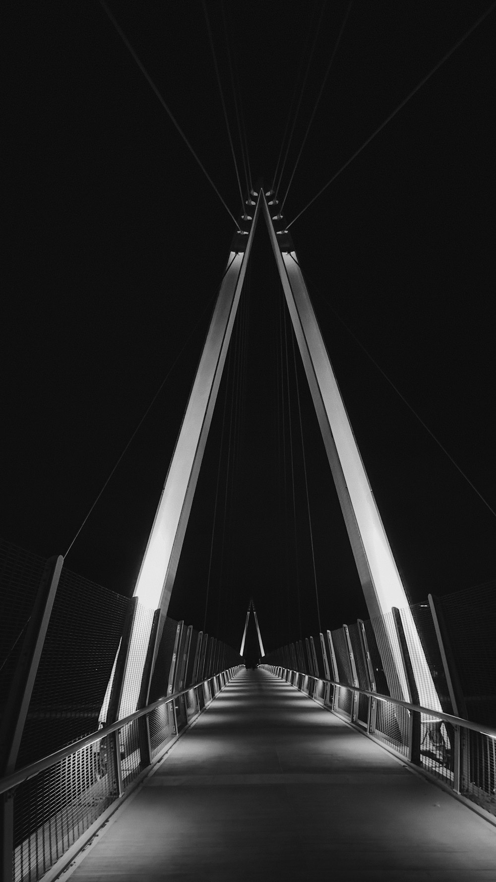 a black and white photo of a bridge at night