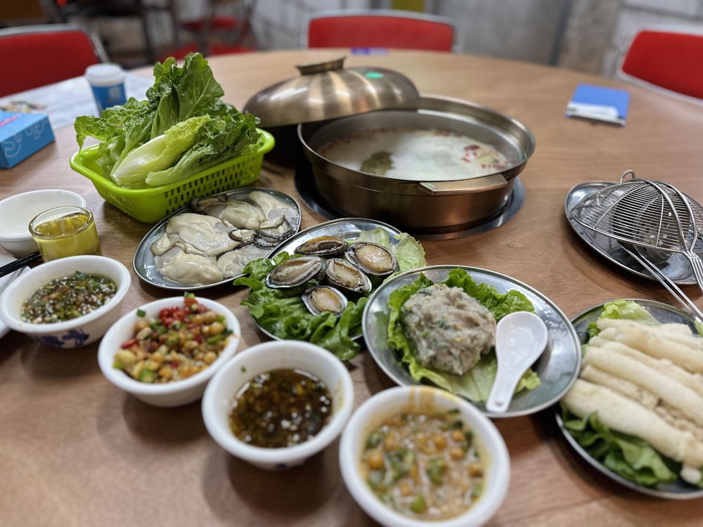 a wooden table topped with bowls of food