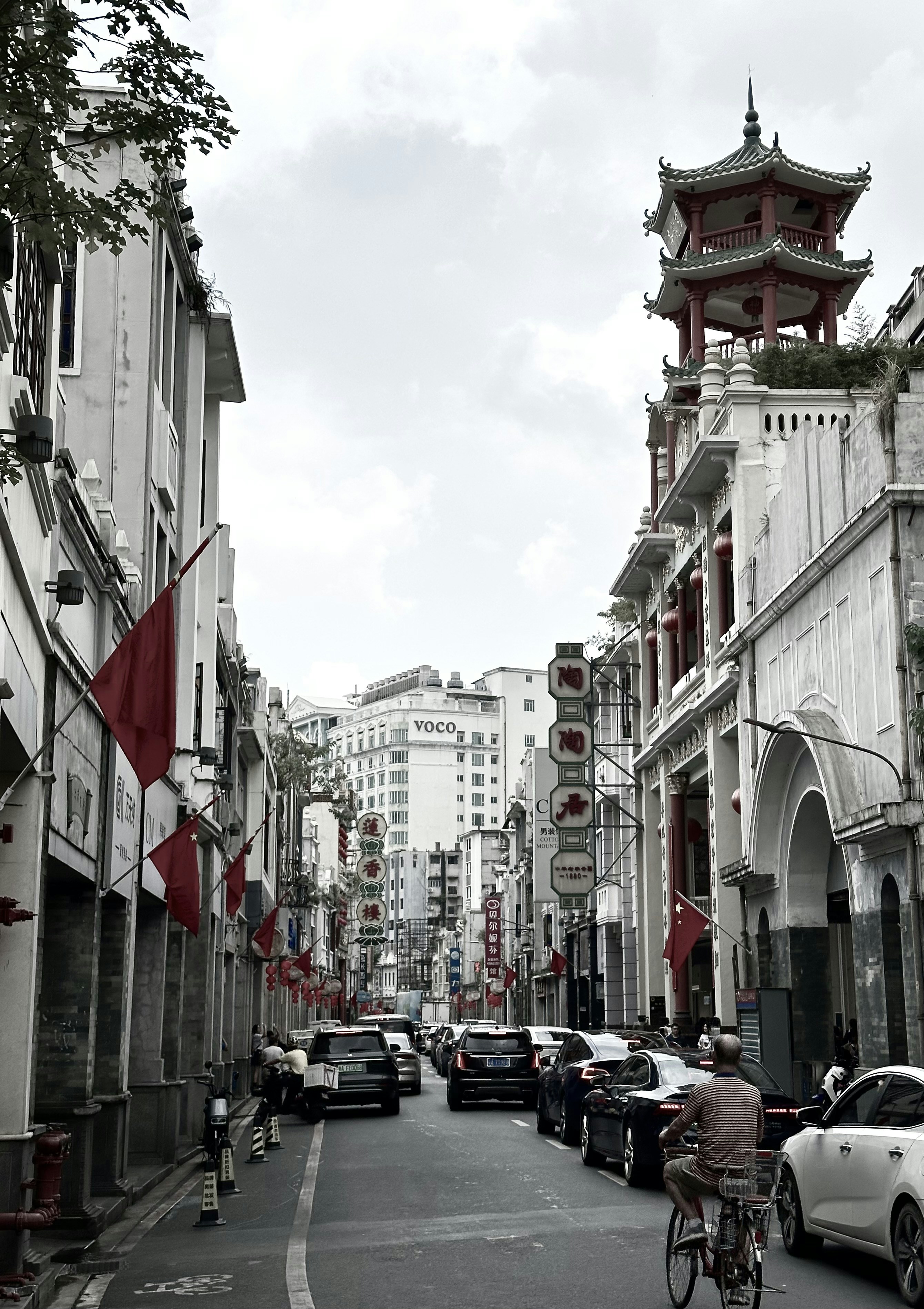 a man riding a bike down a street next to tall buildings