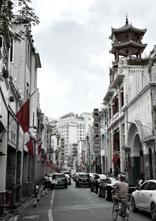 a man riding a bike down a street next to tall buildings