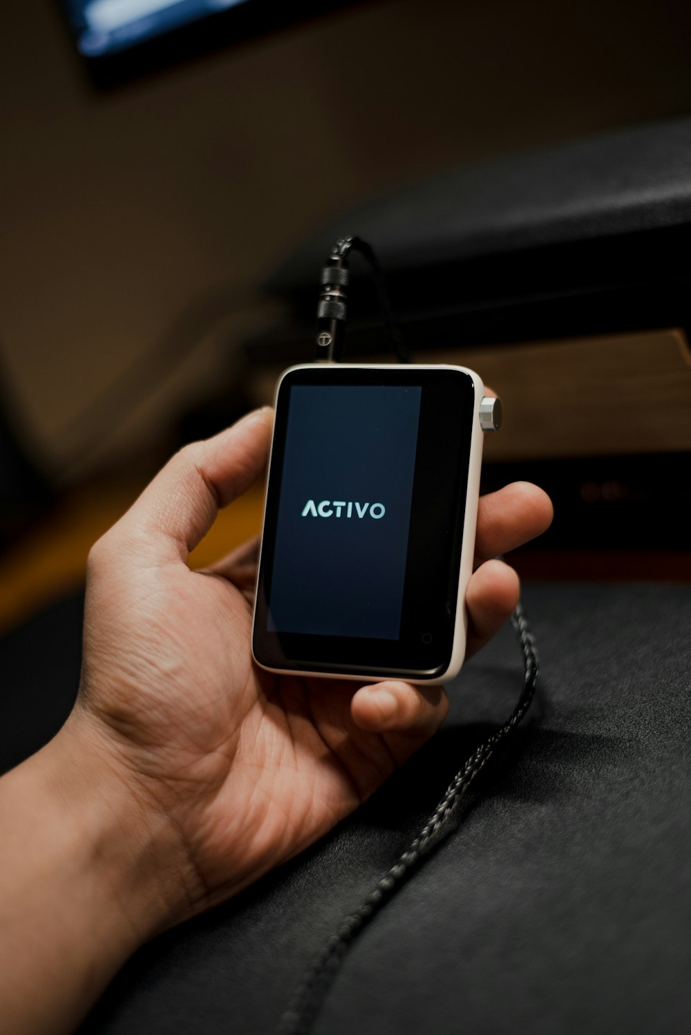 a person holding a smart phone with the word activq on it