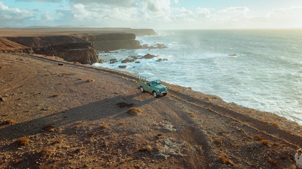 A rugged SUV parked on a coastal road, symbolizing adventure and reliability.