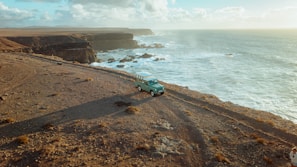 A rugged pickup truck ready for adventure on a coastal road with ocean views.