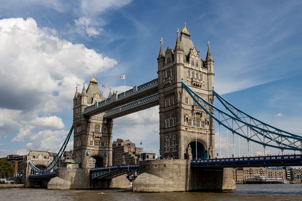 a tall bridge spanning over a river next to a tall building