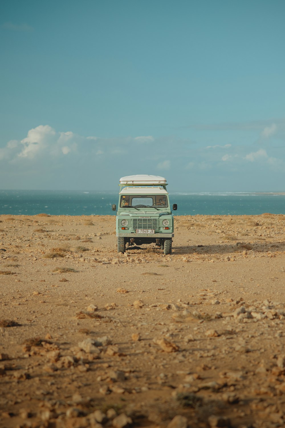 a van is parked on the beach near the ocean