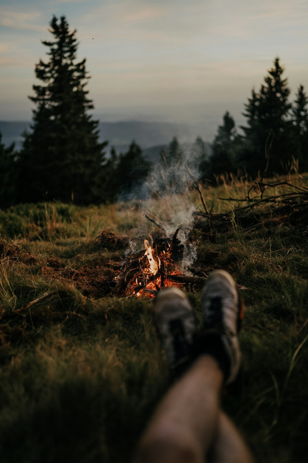 a person standing next to a fire in a field