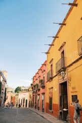 a person standing outside of a yellow building