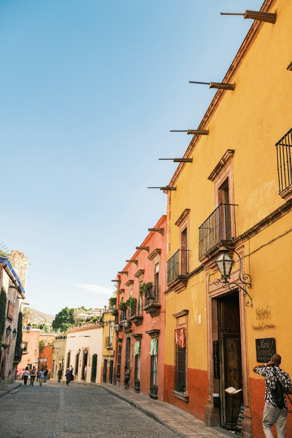 a person standing outside of a yellow building