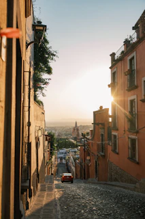 a car is parked on a cobblestone street