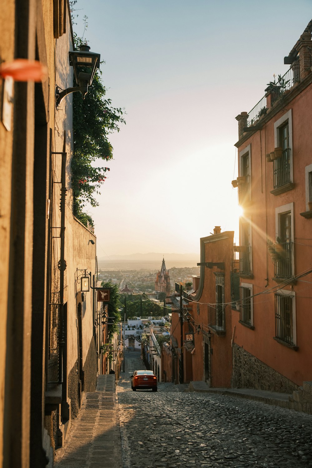 a car is parked on a cobblestone street