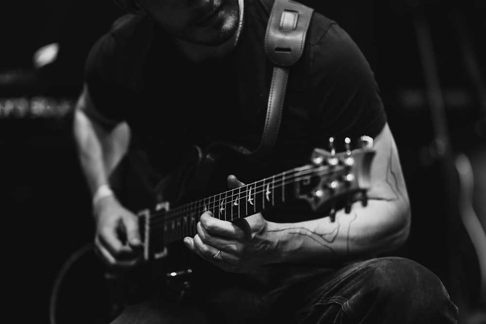 a man playing a guitar in a black and white photo