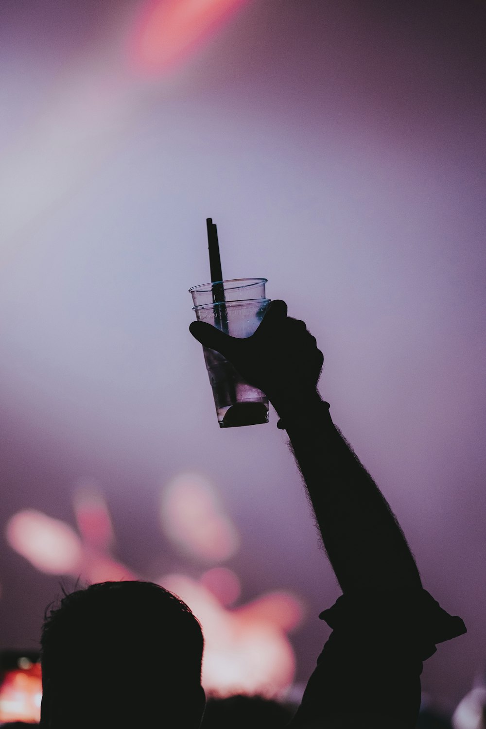 a person holding up a glass with a liquid in it